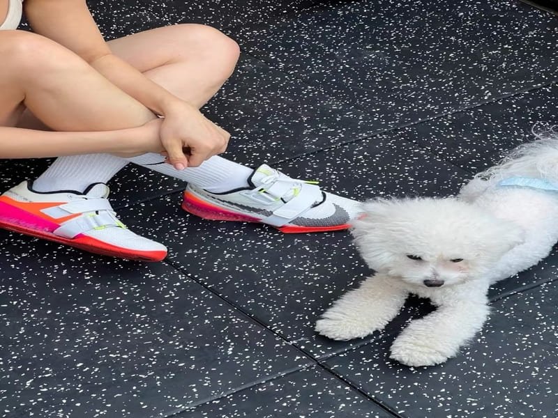 A person measuring the thickness of a rubber gym tile with calipers.